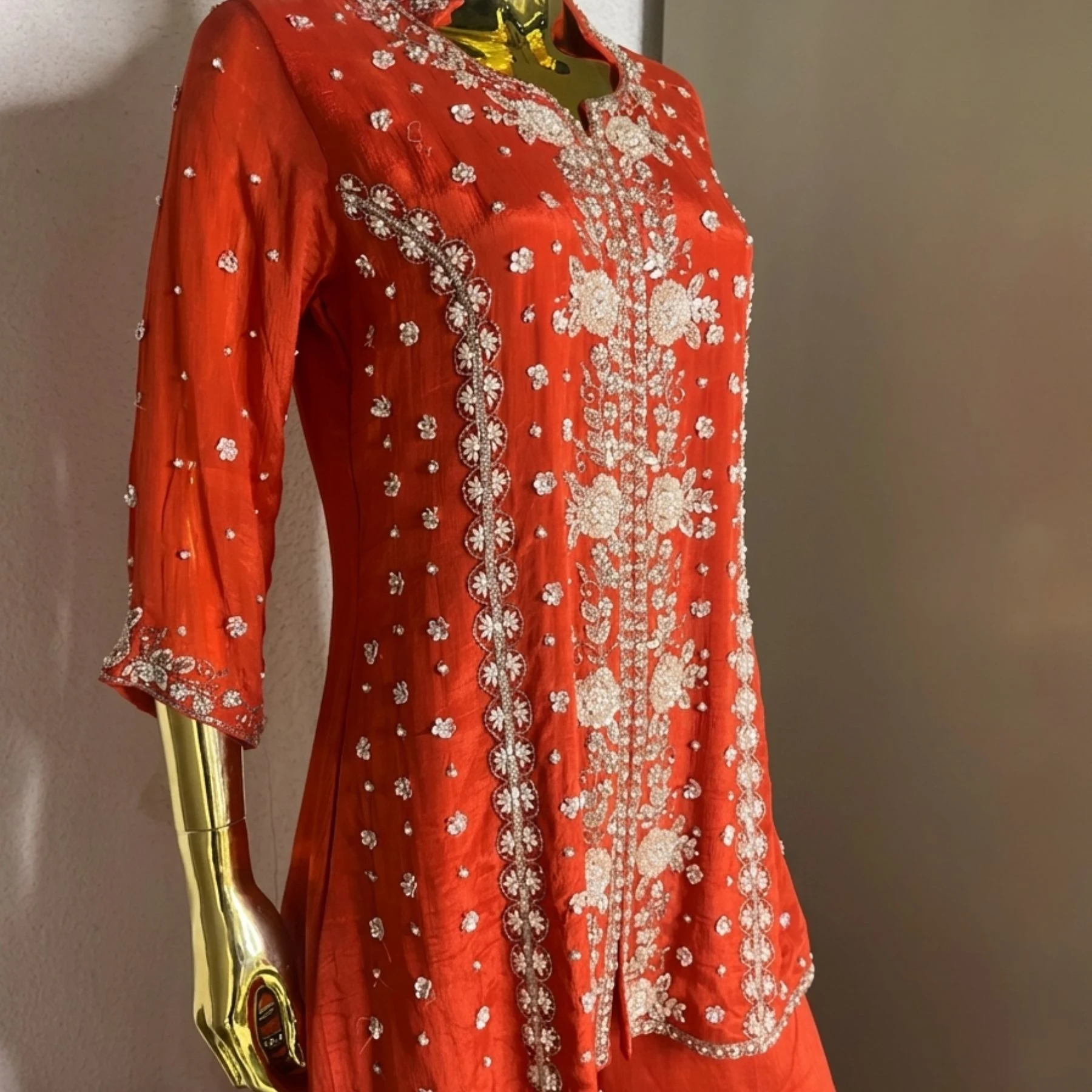 Woman wearing orange chinnon pearl work embroidered co-ord set