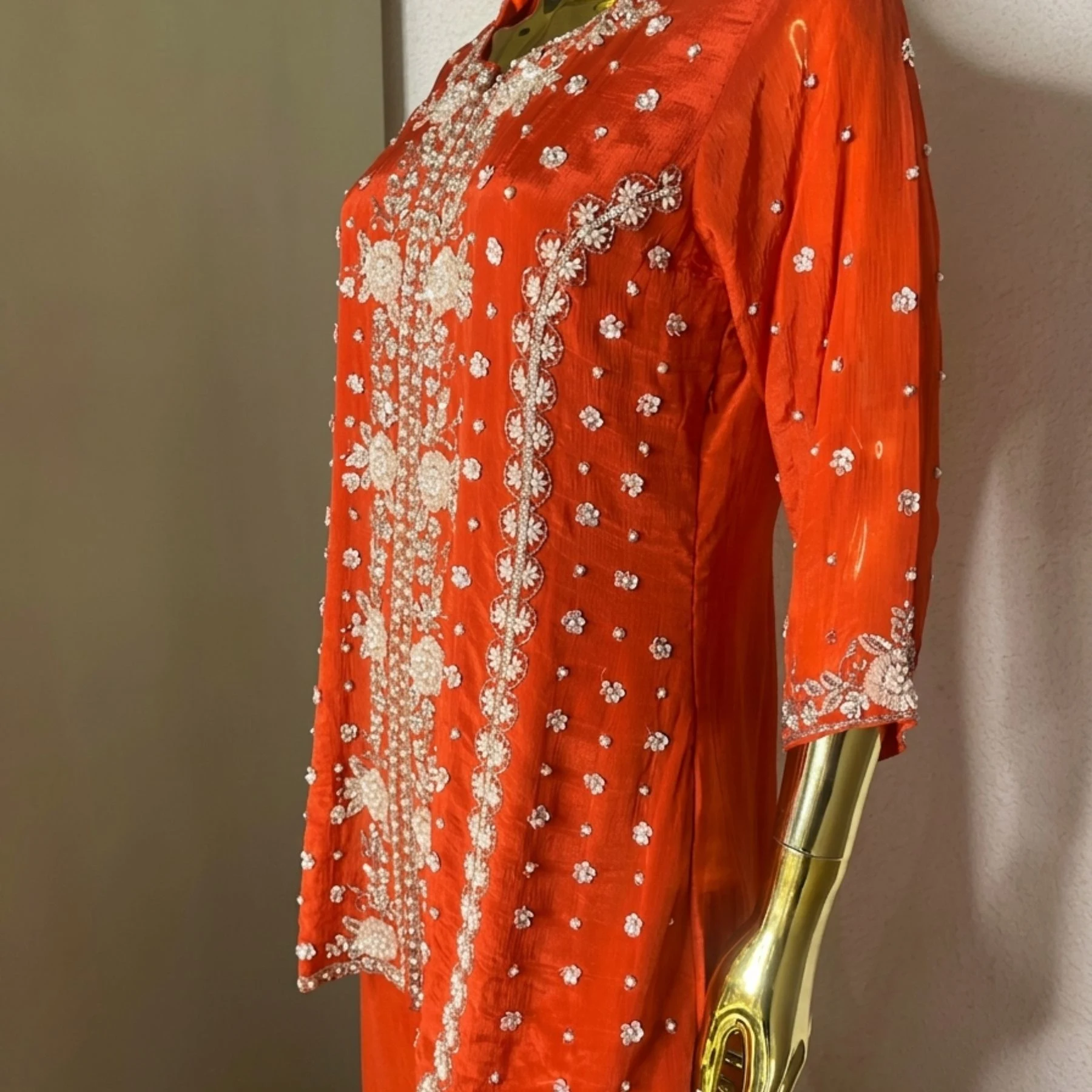 Woman wearing orange chinnon pearl work embroidered co-ord set