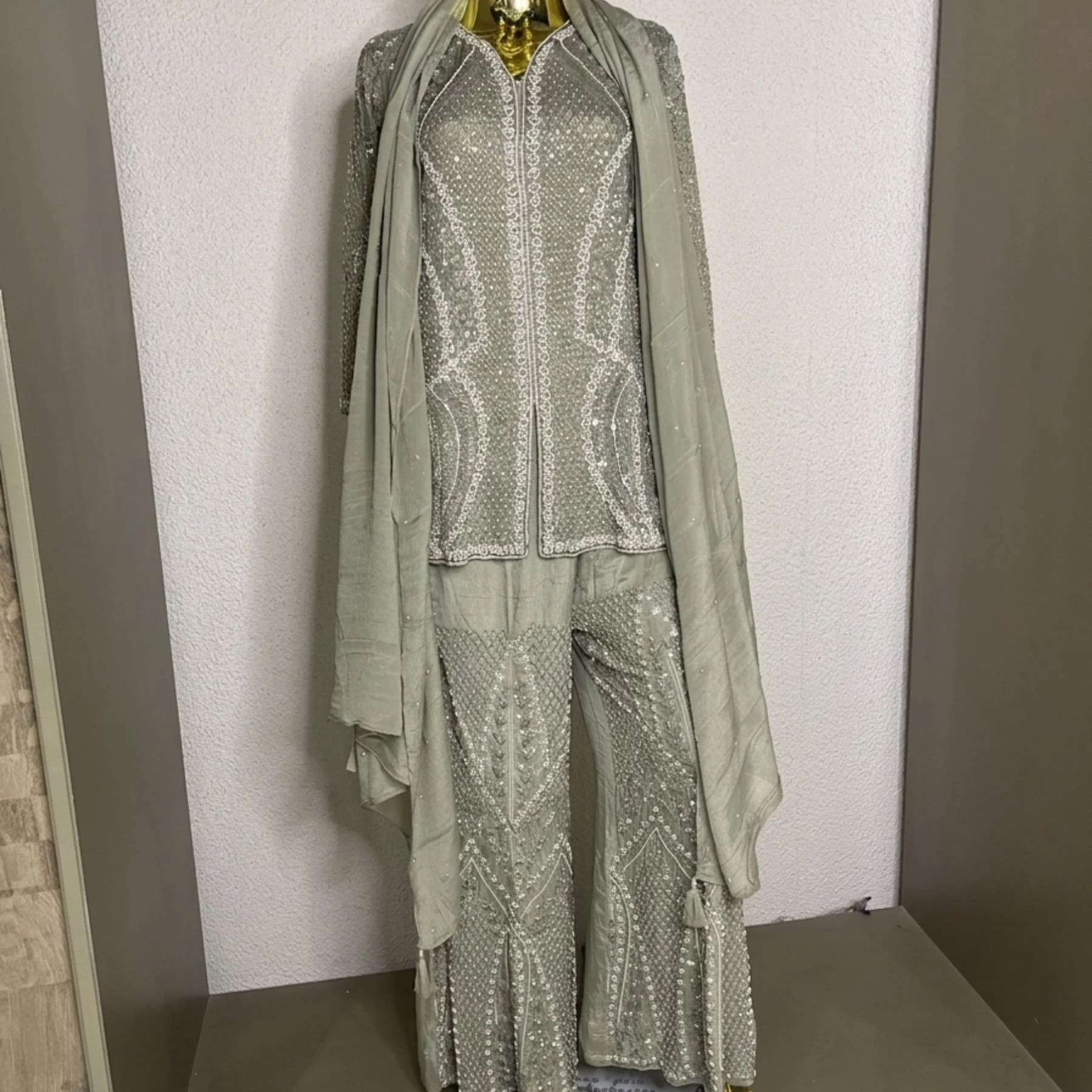 Woman wearing sage green organza pearl work co-ord set with dupatta