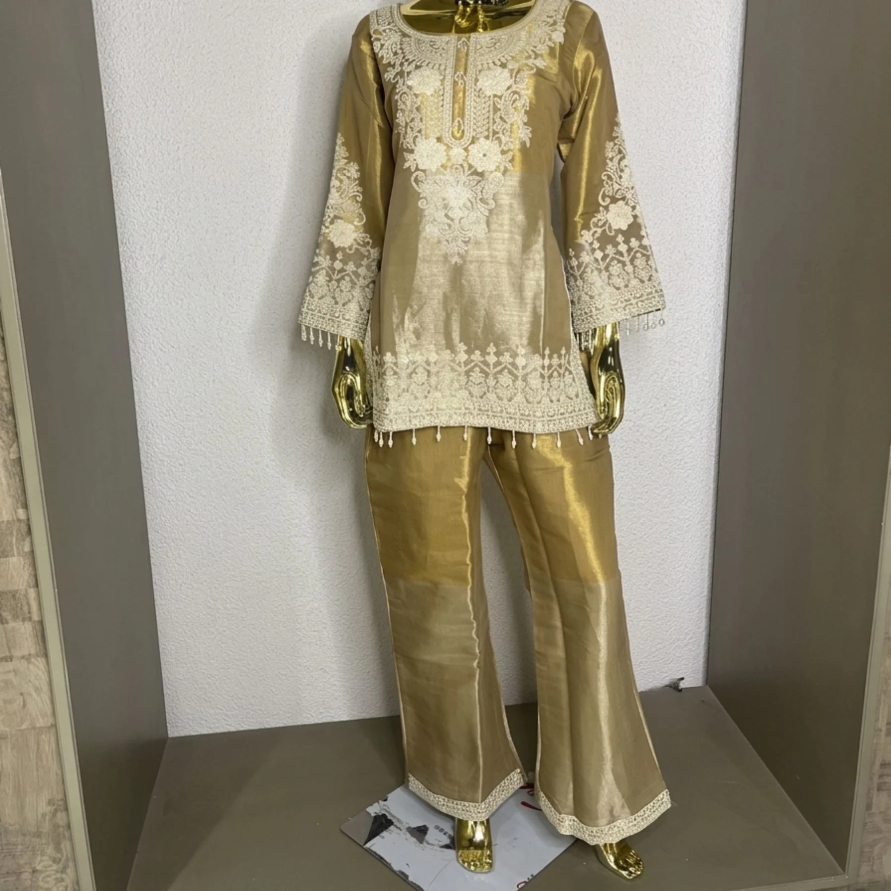 Woman wearing gold shimmer pearl work bell bottom co-ord set with dupatta